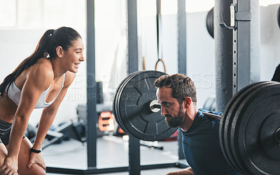 Buy stock photo Shot of a man working out with the help of his coach at the gym