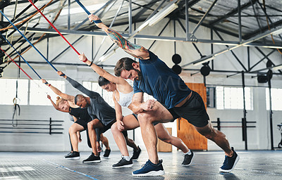 Buy stock photo Full length shot of a group of young athletes going through their warmup routine in the gym