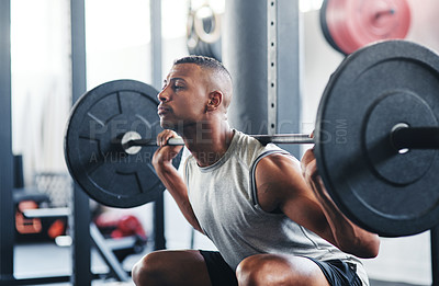 Buy stock photo Cropped shot of a young man working out with a barbell at the gym