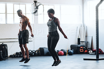 Buy stock photo Portrait shot of two young athletes using skipping ropes while working out at the gym