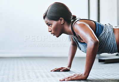 Buy stock photo Cropped shot of a fit young woman doing pushups at the gym