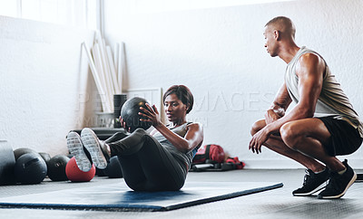 Buy stock photo Shot of a woman working out with the help of her coach at the gym
