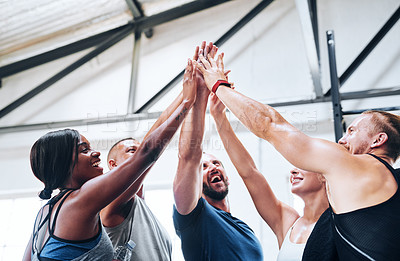 Buy stock photo Shot of a group of people joining their hands together while working out at the gym