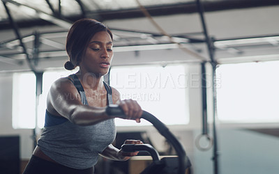 Buy stock photo Shot of a young woman working out on an exercise bike in a gym