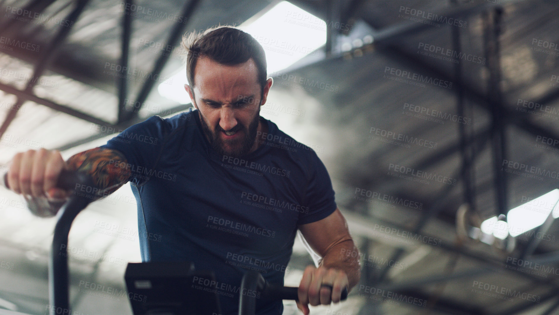 Buy stock photo Stationary bike, intense and fitness with man in gym for cardio challenge, workout machine and health. Cycling equipment, exercise and training with person in sports club for wellness and energy