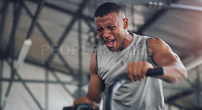 Buy stock photo Shot of a young man working out on an exercise bike in a gym