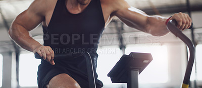 Buy stock photo Closeup shot of an un recognisable man working out on an exercise bike in a gym