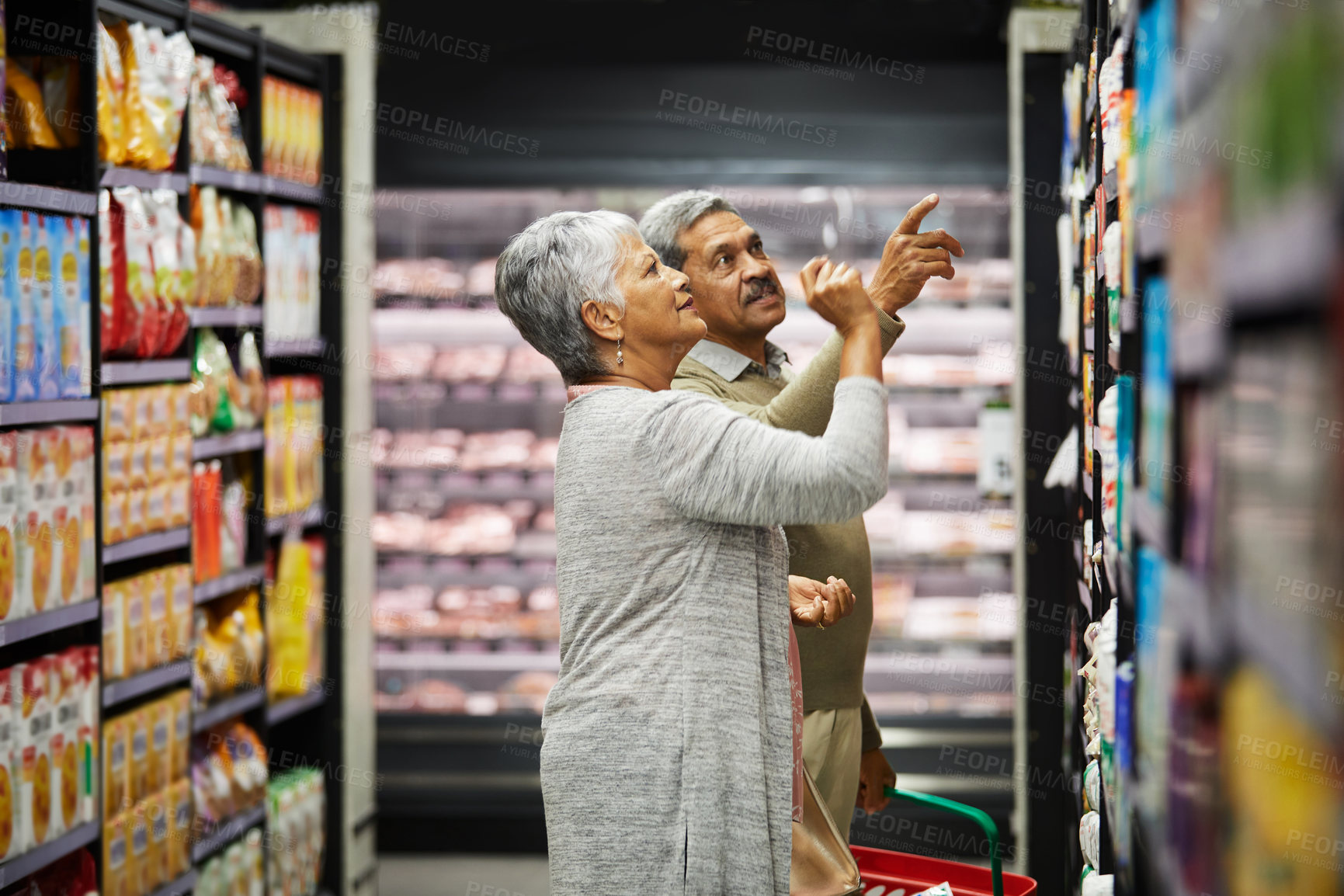 Buy stock photo Shot of a elderly couple grocery shopping in a supermarket