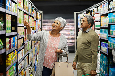 Buy stock photo Shot of a elderly couple grocery shopping in a supermarket