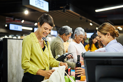 Buy stock photo Shot of a young woman working as a cashier at a supermarket
