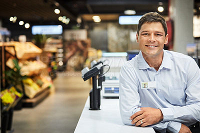 Buy stock photo Shot of a man working as a cashier at a supermarket