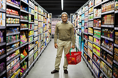 Buy stock photo Shot of a mature male shopping for groceries in a supermarket
