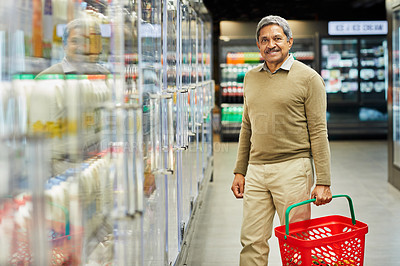 Buy stock photo Shot of a mature male shopping for groceries in a supermarket
