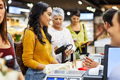 Buy stock photo Shot of a group of people paying for the groceries at a till
