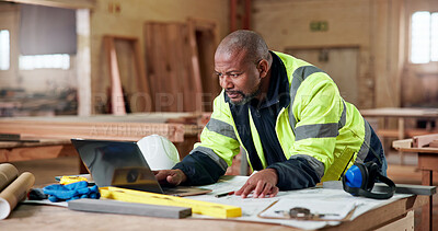 Buy stock photo Carpentry, documents and laptop with black man in workshop for checklist or online order. Computer, paperwork and planning with mature carpenter in woodworking factory for digital agenda or schedule