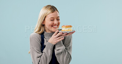 Buy stock photo Happy, woman and waitress in studio with dessert, bakery treats or excited for coffee shop hospitality. Person, cafe worker and customer service with smile, cake and mockup space on blue background.