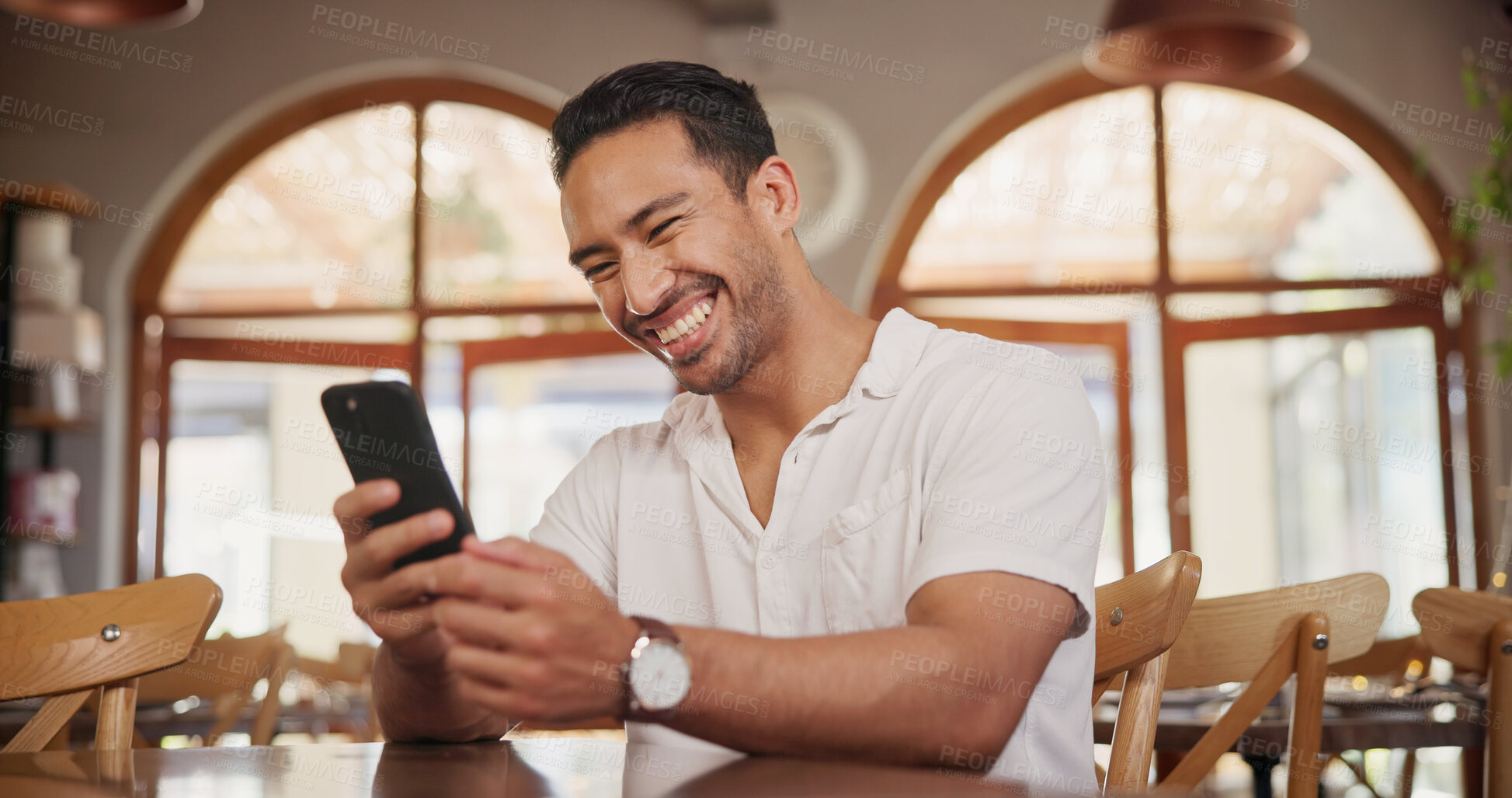 Buy stock photo Laughing, phone and scroll with man in restaurant for online review, communication and menu search. Coffee shop rating, funny meme and contact with person and tech for social media, relax and chat