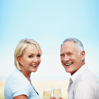 Buy stock photo A portrait of a happy mature couple drinking champagne outdoors