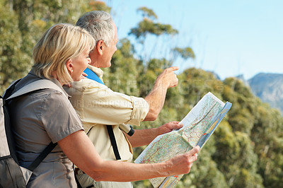 Buy stock photo Shot of a senior couple using a map while standing in a forest
