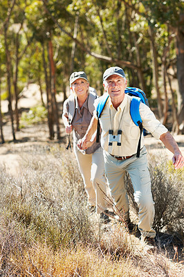 Buy stock photo A shot of a senior man pulling his wife by the hand while walking in the forest
