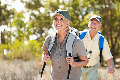 Buy stock photo Shot of an adventurous senior couple walking together in the forest