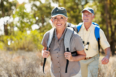 Buy stock photo Shot of an adventurous senior couple walking together in the forest