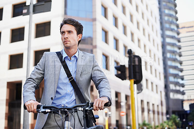 Buy stock photo A handsome businessman standing with his bicycle in the city central