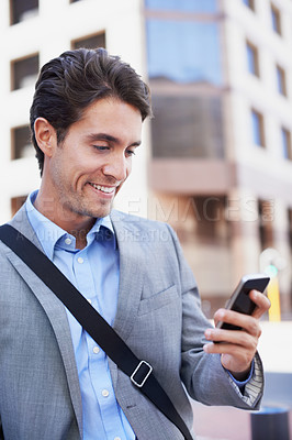 Buy stock photo A handsome businessman using his mobile in the city central