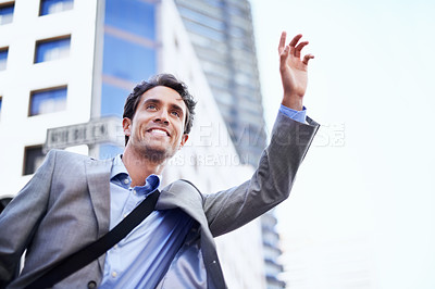 Buy stock photo A handsome businessman hailing a taxi in the city