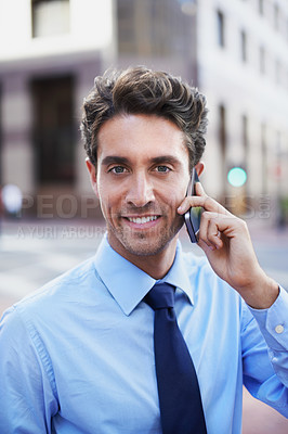 Buy stock photo A handsome businessman on his cellphone while in the city central