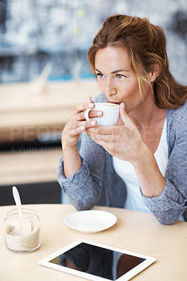 Buy stock photo Woman sitting in coffee shop with her touchscreen in front of her sipping on her coffee looking contemplative