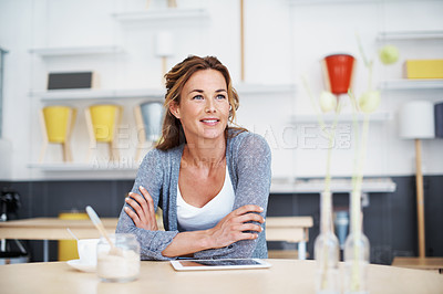 Buy stock photo A woman sitting in a coffee shop with her touchscreen and coffee in front of her looking contemplative