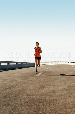 Buy stock photo Young woman jogging in the distance on a highway