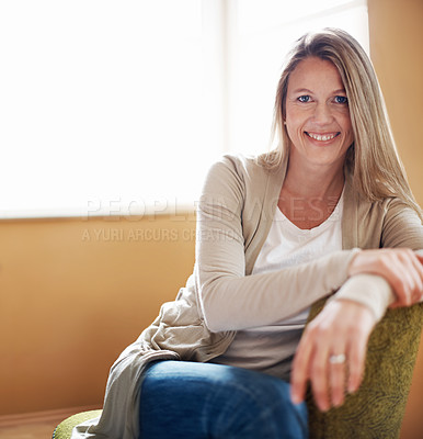 Buy stock photo A beautiful woman sitting on a chair in her living room with copyspace