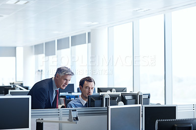 Buy stock photo Shot of a senior businessman looking at a young colleague's computer screen