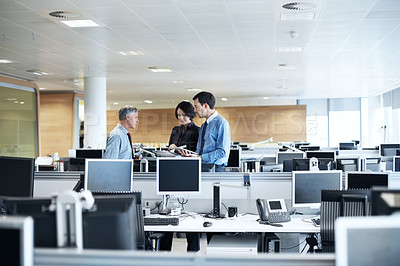 Buy stock photo Shot of three businesspeople discussing something in the office