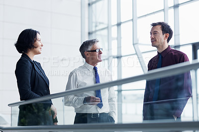 Buy stock photo Shot of three businesspeople having a conversation indoors