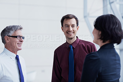 Buy stock photo Shot of three businesspeople having a conversation indoors