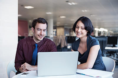 Buy stock photo Shot of two businesspeople looking at a laptop together
