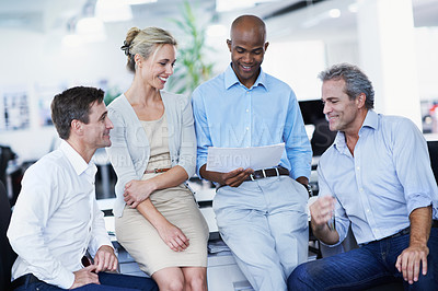 Buy stock photo Shot of a group of businesspeople discussing paperwork in an office