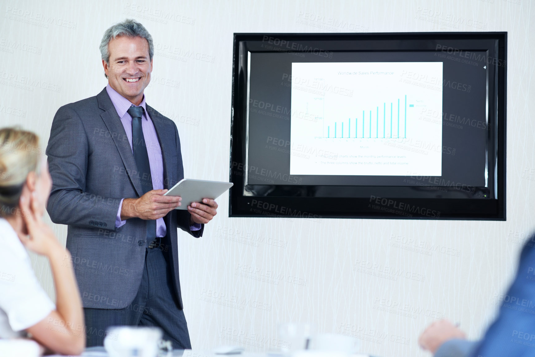 Buy stock photo Businessman, screen and tablet in presentation with smile, graphs or revenue info at finance agency. Happy boss, people and monitor with chart for sales performance, discussion and technology