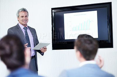 Buy stock photo Shot of a mature businessman giving a video presentation to colleagues in a boardroom