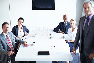 Buy stock photo Portrait of a diverse group of businesspeople sitting around a boardroom table