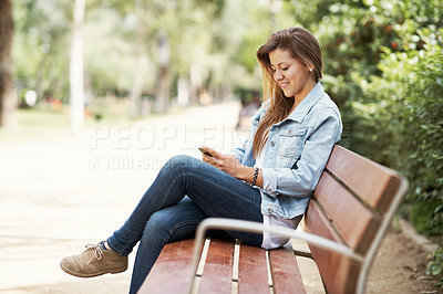 Buy stock photo Attractive young teen using her mobile while outdoors