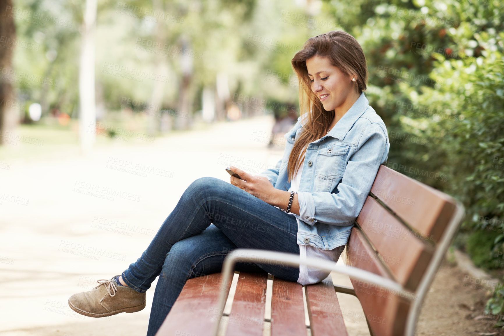 Buy stock photo Phone, student and texting with woman on park bench for college application, social media or smile. University portal, online academy review or communication with person outdoor for campus newsletter