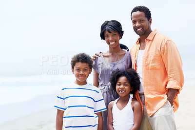 Buy stock photo A happy Afircan-American family standing on the beach