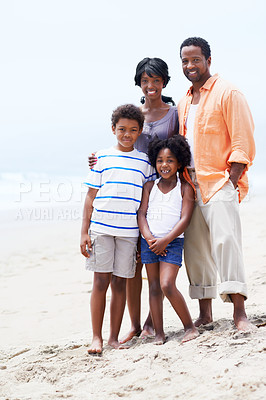 Buy stock photo A happy Afircan-American family standing on the beach