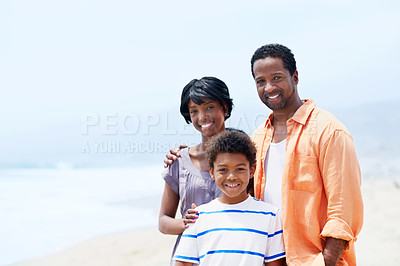 Buy stock photo A young African-American family standing with their young son on the beach