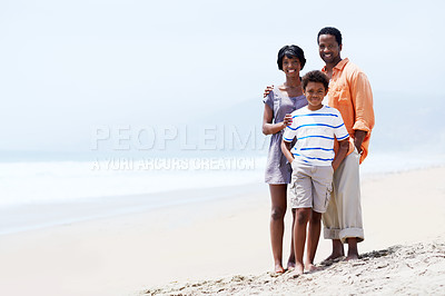 Buy stock photo A young African-American family standing with their young son on the beach