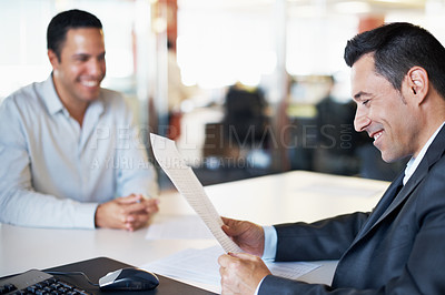 Buy stock photo A manager and his coworker expressing positivity while discussing some paperwork